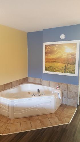 eine große weiße Badewanne in einem Zimmer mit einem Gemälde in der Unterkunft Days Inn by Wyndham Trenton in Trenton