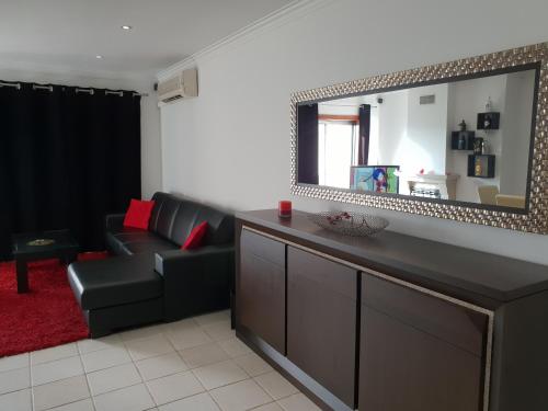 ein Wohnzimmer mit einem Sofa und einem Spiegel in der Unterkunft Bloco 3 Agueda in Águeda