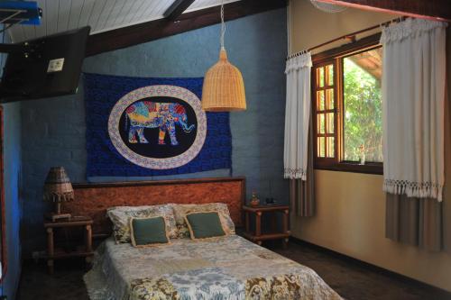 um quarto com uma cama e um quadro na parede em Pousada Manacás em Cavalcante