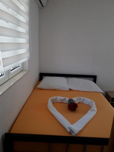 a bedroom with a bed with a heart shaped bedspread at Studio Apartment Sanja 4 in Neum