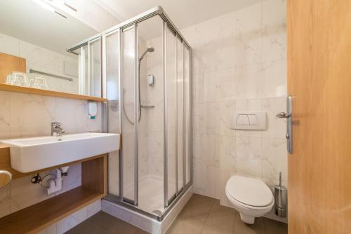 a bathroom with a shower and a sink and a toilet at Hotel Taufers in Molini di Tures