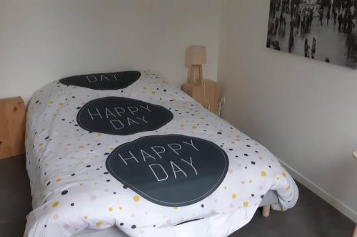 ein Bett mit zwei Happy Day Kissen drauf in der Unterkunft Elbeuf Etage 1 sweet home Netflix wifi in Elbeuf