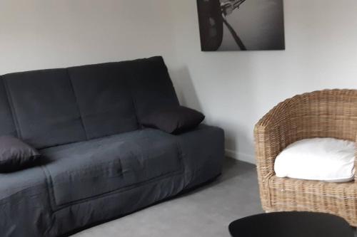 eine schwarze Couch und ein Stuhl im Wohnzimmer in der Unterkunft Elbeuf Etage 1 sweet home Netflix wifi in Elbeuf