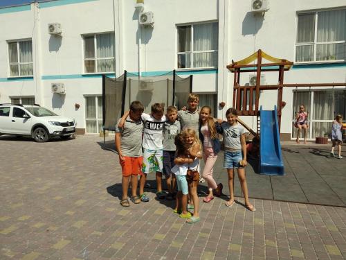 a group of children standing next to a playground at Grand Victoria Hotel in Kyrylivka
