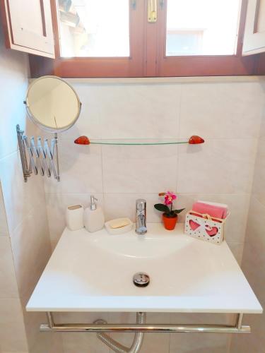 a bathroom sink with a mirror and flowers on it at Siracusa Ortigia by Duomo in Siracusa