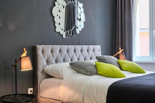 a bedroom with a bed with green pillows and a mirror at Hedone Luxury 3 Apartments with FREE PARKING in Pula