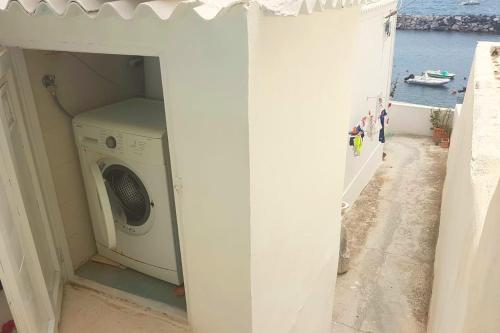 a washing machine in a room with a view of the ocean at Casa Gastronomo in Procida
