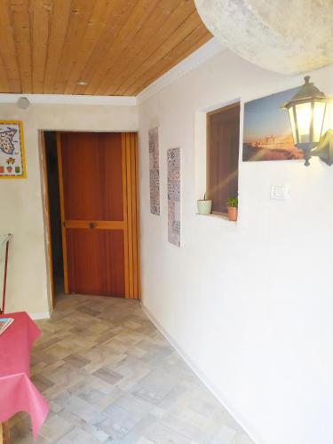 a hallway with a door and a table and a lamp at Siracusa Ortigia by Duomo in Siracusa