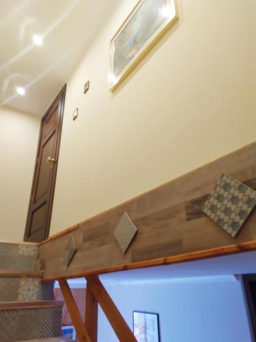 a stairway with a wooden rail in a room at Siracusa Ortigia by Duomo in Siracusa