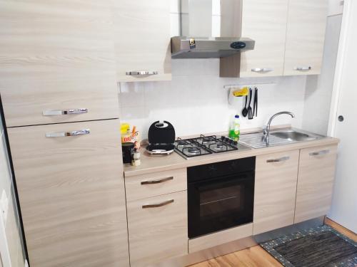 a kitchen with a stove and a sink at Siracusa Ortigia by Duomo in Siracusa