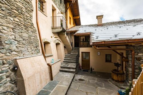 a stairway leading up to a building with snow on the roof at Chambres d'hôtes La Moraine Enchantée in Aosta