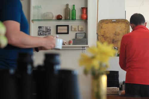 a man standing in a kitchen holding a coffee cup at Magic Mountain Lodge - Lyngen in Lyngseidet