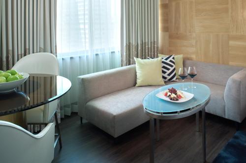 a living room with a couch and a table with a plate of food at Sofitel Philadelphia at Rittenhouse Square in Philadelphia