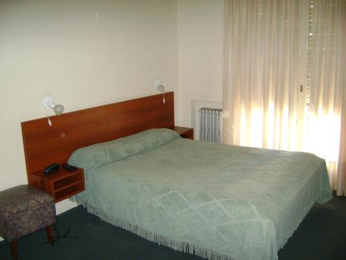 a bedroom with a bed and a chair and a window at Real Splendid Hotel in Buenos Aires