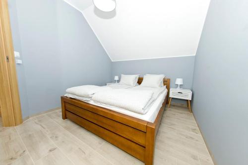Schlafzimmer mit einem Bett mit weißer Bettwäsche in der Unterkunft Lenovo in Mosty