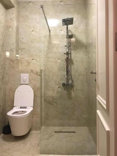 a bathroom with a toilet and a glass shower at Hotel Dardani in Mitrovicë