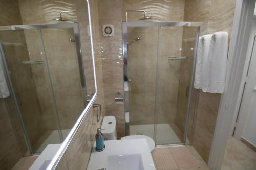 a bathroom with a shower and a toilet and a sink at Sonnenland Meloneras & Maspalomas in Maspalomas