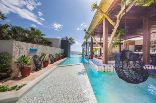 una piscina con columpio en un complejo en Mi Amor Boutique Hotel-Adults Only en Tulum