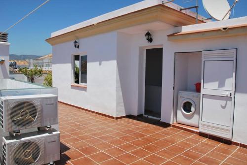 ein Haus mit einer Waschmaschine auf einer Terrasse in der Unterkunft Apartamentos Centurión in Nerja