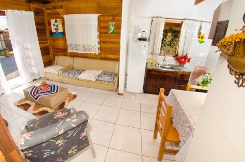 ein Wohnzimmer mit einem Sofa und einem Tisch in der Unterkunft Chalés da Sinhá in Penha
