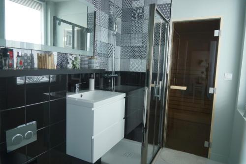 a bathroom with a sink and a glass shower at Studio privatisé avec terrasse dans maison de charme angevine in Angers