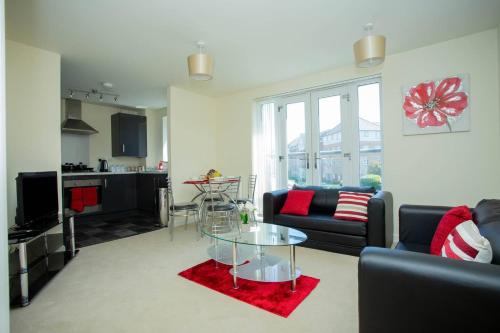 a living room with a couch and a glass table at Lake View Apartment in Northampton