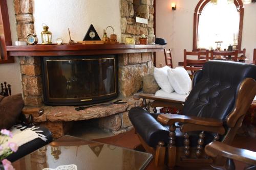 a living room with a tv and a stone fireplace at Villa Serz in Bitola