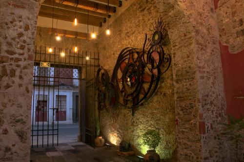 Habitación con pared de piedra y lámpara de araña. en Hotel el Descanso Barrio del Artista, en Puebla