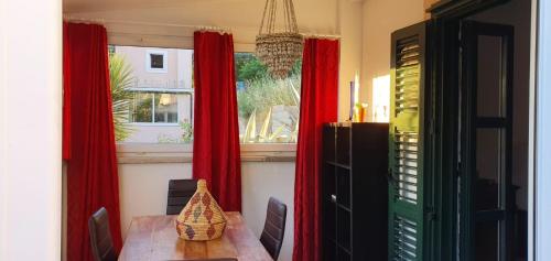 ein Esszimmer mit roten Vorhängen und einem Tisch in der Unterkunft Appartement Mila in Hvar