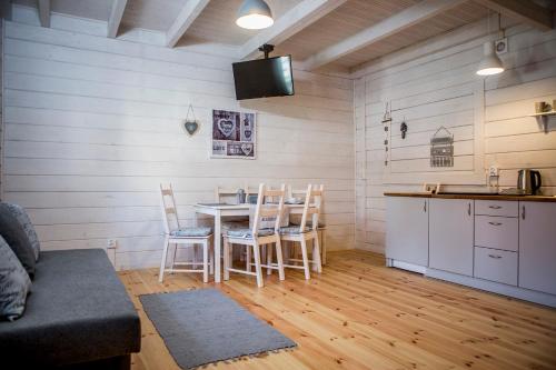 a kitchen and dining room with a table and chairs at biale domki in Pobierowo