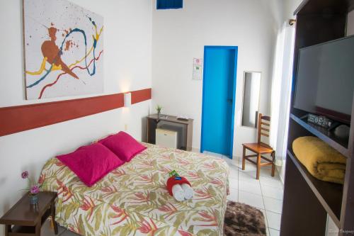 a bedroom with a bed and a flat screen tv at Pousada Villa Del Rey POSSUIMOS GERADOR in Paraty