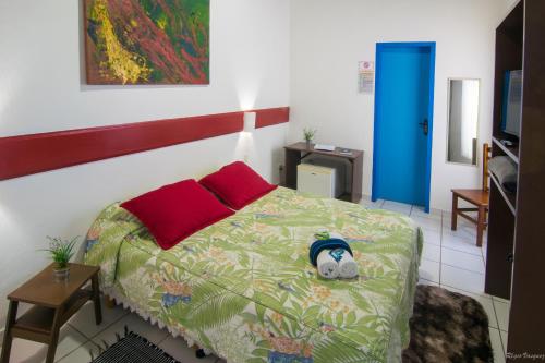 a bedroom with a bed with a stuffed animal on it at Pousada Villa Del Rey POSSUIMOS GERADOR in Paraty