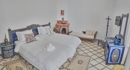 a bedroom with a bed with a white comforter at Riad Borj El Baroud in Essaouira