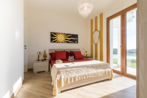 a bedroom with a bed and a large window at Villa Dama luxury in Alghero