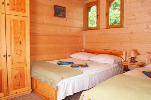 1 dormitorio con 2 camas en una cabaña de madera en Willa Pod Nosalem I en Zakopane