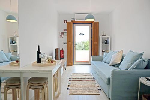 a living room with a blue couch and a table at Mood Lodging Caldas & Ocean in Óbidos