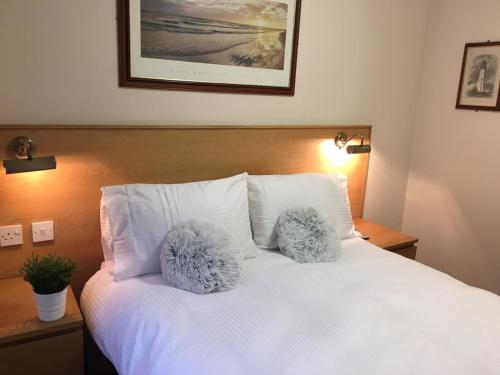 Una cama con dos almohadas peludas encima. en Terra Nova Hotel, en Aberdeen