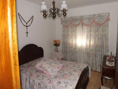 a bedroom with a bed and a chandelier at A casa da vila in Sousel