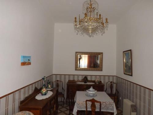 a dining room with a table and a chandelier at A casa da vila in Sousel