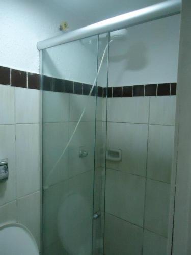 a glass shower in a bathroom with a toilet at Pousada do Turista in Fortaleza