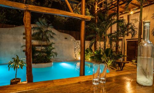 a pool in a room with a table and glasses at Hotel Boutique TerraNova in Tulum