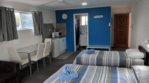a room with two beds and a table and a kitchen at Harrington Village Motel in Harrington
