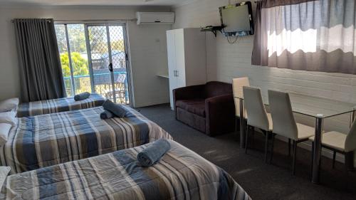 a room with two beds and a table and chairs at Harrington Village Motel in Harrington