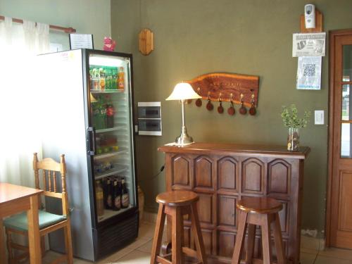 een kamer met een bar met krukken en een koelkast bij Hostería San Benito in Concordia
