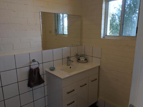 a bathroom with a sink and a mirror at Harrington Village Motel in Harrington