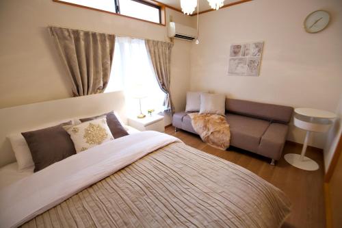 a bedroom with a large bed and a couch at The 3rd Residential Suite SHIROKANE in Tokyo