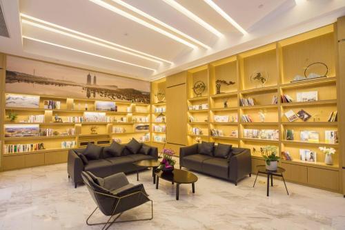 una biblioteca con sofás y estanterías de libros en Atour Hotel Development Avenue Suqian en Suqian