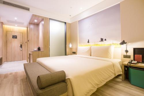 Habitación de hotel con cama grande y TV en Atour Hotel Development Avenue Suqian en Suqian