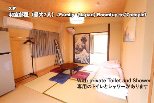 広島市にあるRED HELMET House & Sports Bar Hiroshimaのベッド1台、冷蔵庫が備わる小さな客室です。