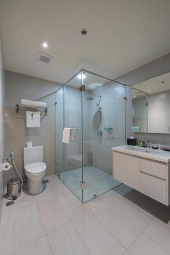 a bathroom with a shower and a toilet and a sink at Citadines Millennium Ortigas Manila in Manila